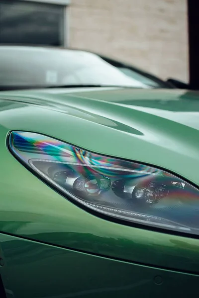 超级跑车的前灯 与这款跑车华丽明亮的绿色油漆形成了鲜明对比 位于联合王国曼彻斯特 宏观射门 — 图库照片