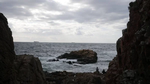 Kasvetli Bir Günde Kayaların Üzerinde Oturup Okyanus Dalgalarının Sahile Vuruşunu — Stok fotoğraf