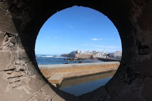 一个特写镜头从一个圆形的孔窗户射向海边的建筑物 — 图库照片