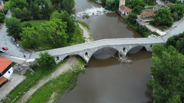 Bir köyün havadan görünüşü ve nehrin üzerindeki bir köprü.