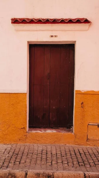 Disparo Vertical Una Puerta Madera Una Vieja Pared Naranja Blanca —  Fotos de Stock