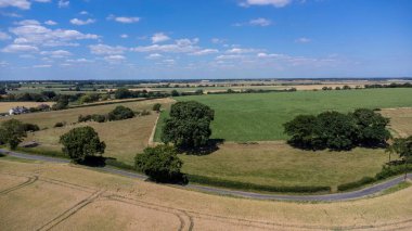 Mavi gökyüzü arka planında kırsal bir alandaki tarımsal arazilerin manzarası