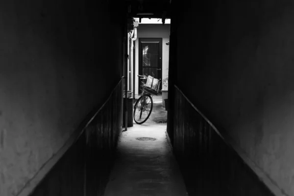 Gråskala Korridor Som Leder Till Cykel Parkerad Bakgård — Stockfoto