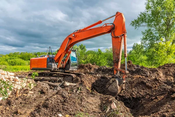 Gran Excavadora Orugas Naranja Está Excavando Cavando Una Zanja Contra —  Fotos de Stock