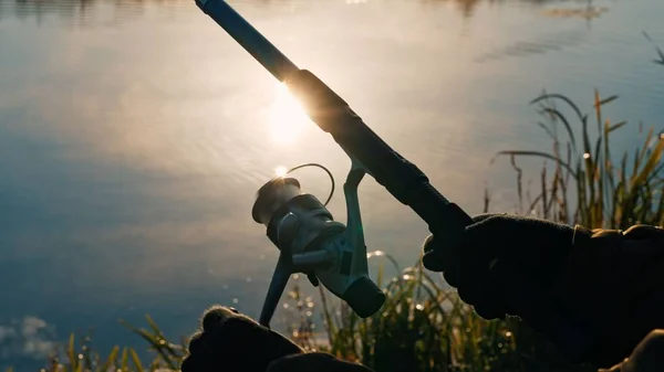 Tiro Close Mão Masculina Segurando Vara Pesca Pôr Sol Empoeirado — Fotografia de Stock