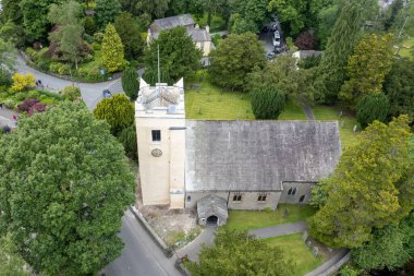 A bird's eye view of the St. Oswald's Church, Grasmere surrounded by green trees in England clipart