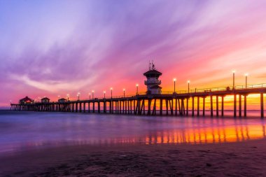 Gün batımında bir rıhtımda uzun bir deniz manzarası.