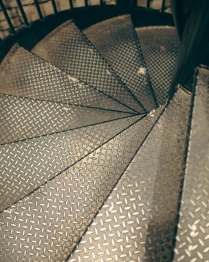 Girdap gibi metal bir merdiven aşağı inerken dikey bir görüntü.