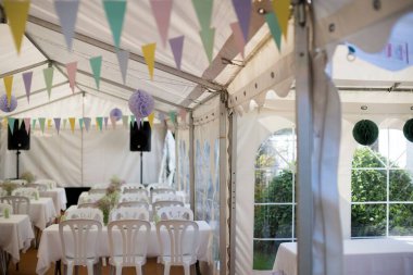 Danimarka 'nın Kopenhag şehrinde beyaz masalar ve renkli bayraklarla süslenmiş bir düğün salonu.