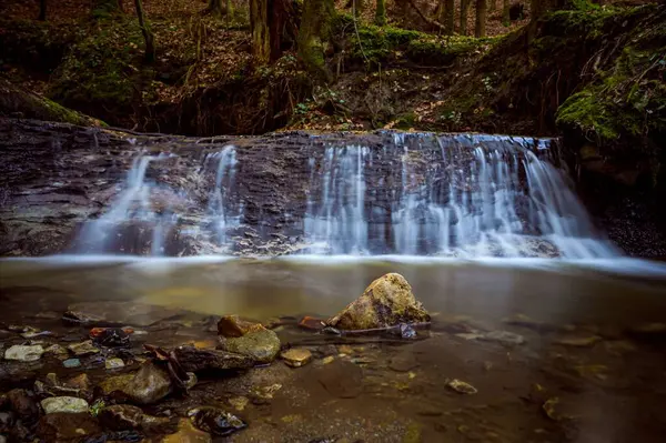 一个小瀑布流过森林里的岩石 — 图库照片