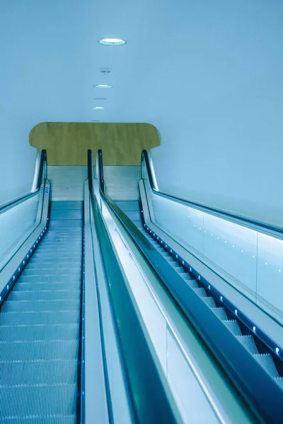 Eine Vertikale Aufnahme Von Rolltreppen Unter Einer Minimalistischen Decke — Stockfoto