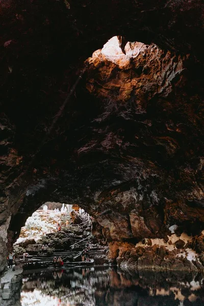 洞内的一条河的垂直截图 顶部有隧道发出的光 — 图库照片