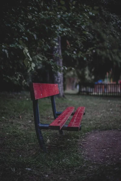 红色木制公园长椅的垂直镜头 — 图库照片