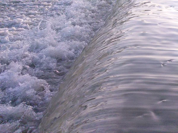 小さなダムの上を流れる泡の水の塊 — ストック写真