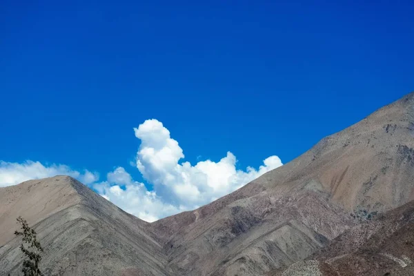 Zbliżenie Ujęcie Góry Chmurami Błękitnym Niebem Tle — Zdjęcie stockowe