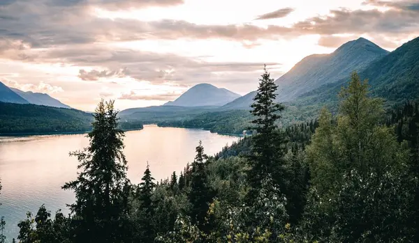 アラスカの雲の下の山々に囲まれた湖の魅惑的なショット — ストック写真