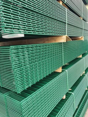 Bir yığın ikiz tel kaynaklı çit örgü, yeşil kaplamalı toz.