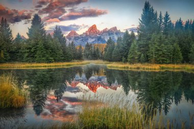 Dağların, ağaçların ve Wyoming 'deki göldeki yansımanın manzarası.