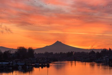 Manzaralı bir dağ manzarası ve suda yansıyan güzel bir gün batımı.
