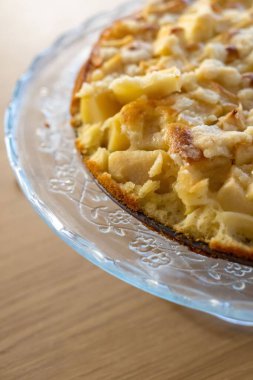 Cam bir tabakta iyi pişmiş elmalı turtanın dikey görüntüsü.