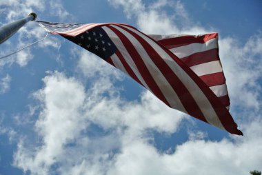 Bulutlu bir gökyüzünde sallanan Amerikan bayrağının alçak açılı görüntüsü