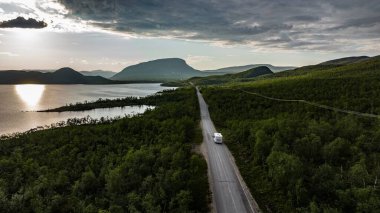 Finlandiya, Kilpisjarvi 'de güneşli bir yaz gününde Saana' ya doğru giden bir karavanın hava görüntüsü düştü.