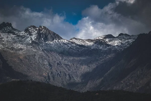 Bulutlu Gökyüzünün Altında Kısmen Karla Kaplı Bir Dağ Manzarası — Stok fotoğraf