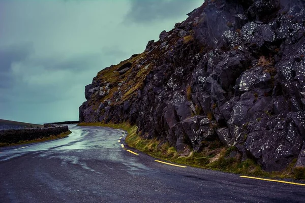 陡峭的山崖边一条蜿蜒曲折的路 — 图库照片