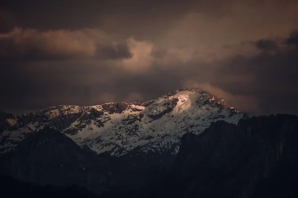 夕日の曇り空の下 雪に覆われた山並みの絶景 — ストック写真