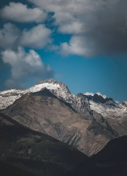 Vertikální Záběr Pohoří Částečně Pokryté Sněhem Pod Zataženou Oblohou — Stock fotografie