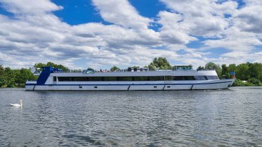 Bulutlu gökyüzünün altındaki gölün ortasındaki güzel bir gemi manzarası.