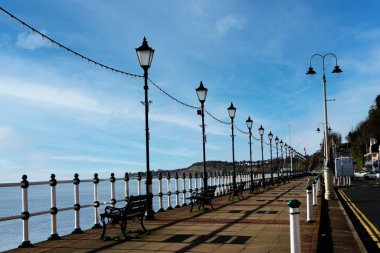 Galler 'de deniz kenarında yürüyen muhteşem mavi bir gökyüzü, sokak ışıklarıyla dolu..