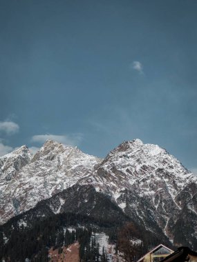 Dhuhadhar 'daki Narmada Nehri yakınlarında mavi gökyüzünün altındaki karlı kayalık dağların dikey görüntüsü.