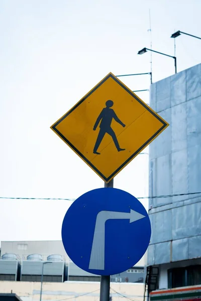 右折を示す青い道路標識と横断歩道標識の垂直方向の眺め — ストック写真