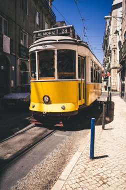 Portekiz 'in Lizbon şehrinde sarı bir tramvayın dikey görüntüsü.