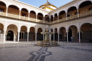 Eski bir ortaçağ binasının bahçesinde güzel süslemeleri olan bir çeşme.