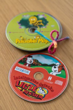 Tahta bir yüzey üzerinde çocuklar için Polonyalı film CD 'lerinin dikey çekimi