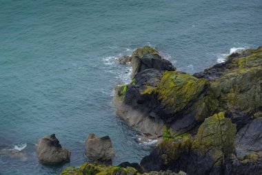 İrlanda Denizi ve kayalık kıyı yağmurlu bir günde yukarıdan görüldü. İrlanda 'nın doğu kıyısının kasvetli deniz manzarası.