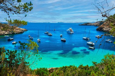 Yelkenliler pitoresk turistik Cala Salada lagününe, İbiza 'ya, Balear Adalarına, İspanya' ya yanaştılar.
