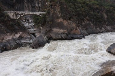 Kayalıkların ortasındaki bir köprünün arka planında akan nehrin güzel bir görüntüsü.