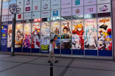 Akihabara, Japonya- 2 Ağustos 2020: Bir adam Akihabara 'da bir dizi anime posterinin yanından geçiyor.