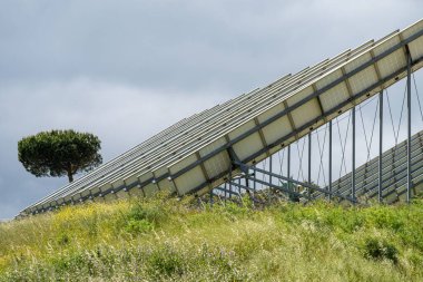 Bulutlu gökyüzünün altındaki bir alandaki güneş panellerinin görüntüsü