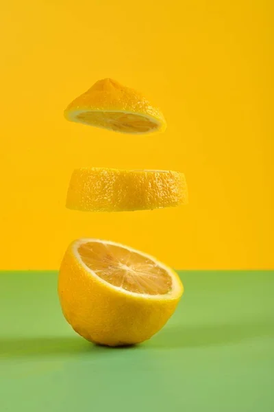 Sarı Arka Planda Yüzen Bir Limon Diliminin Dikey Görüntüsü — Stok fotoğraf