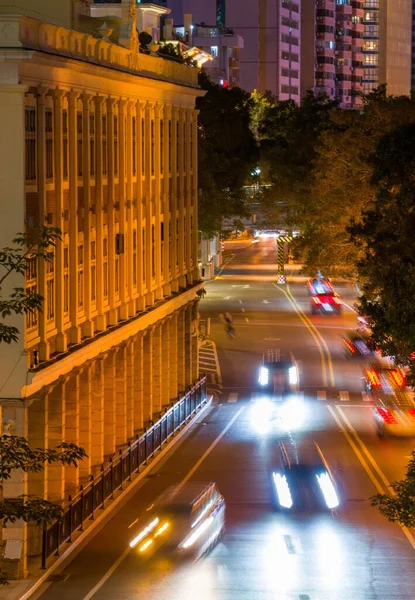 Вертикальный Снимок Вечерней Городской Улицы Освещенными Зданиями Движущимися Автомобилями — стоковое фото