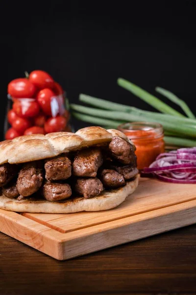 Een Verticaal Shot Gegrild Vlees Brood Uien Saus Tomaten Een — Stockfoto