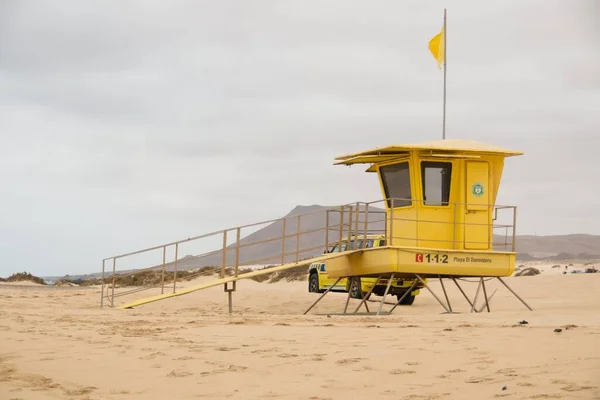 Een Gele Badmeester Cabine Met Een Vlag Het Strand Bewolkte — Stockfoto