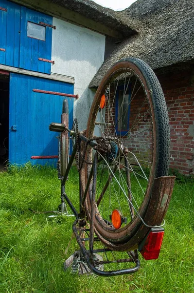 一辆旧的锈迹斑斑的自行车倒在草地上 — 图库照片