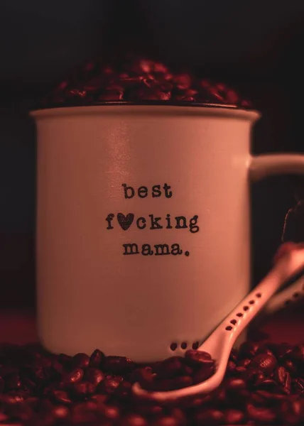 コーヒー豆で満たされた最高の母親の狂気のメッセージとマグカップの垂直ショット — ストック写真