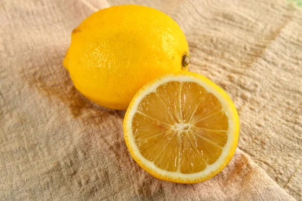 Bir Bütün Kahverengi Bir Kumaş Üzerinde Dilimlenmiş Bir Limon — Stok fotoğraf