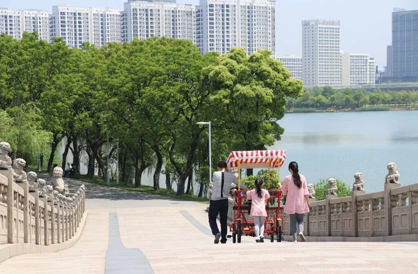 中国苏州 一个年轻的中国家庭 带着一个蹒跚学步的小女孩穿过公园桥 — 图库照片